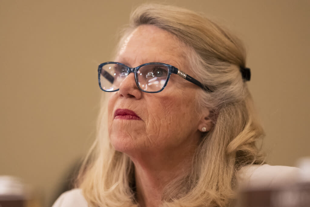 Rep. Carol Miller (R-WV) looks up while a light reflects on her black framed glasses.