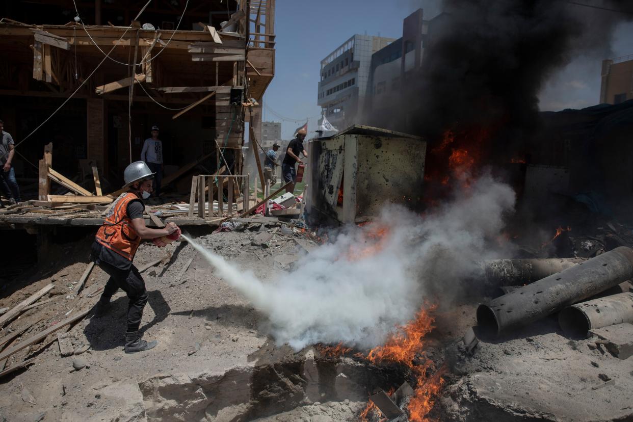 A Palestinian firefighter extinguishes a fire from a beachside cafe after it was hit by an Israeli airstrike in Gaza City on Monday, May 17, 2021.