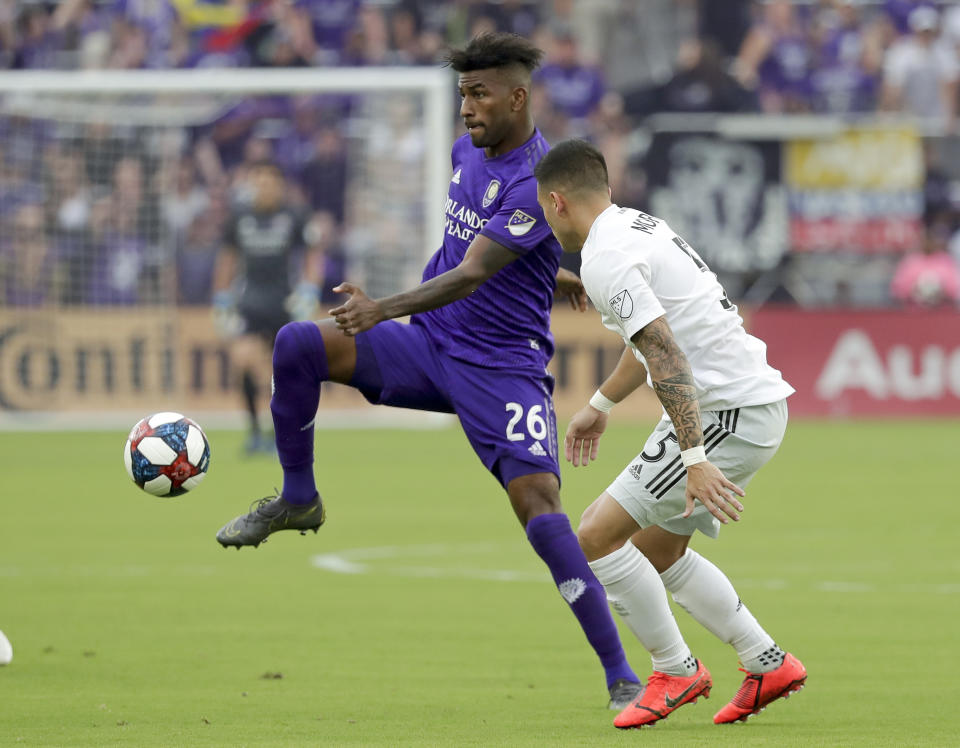 Orlando City's Carlos Ascues, left, moves the ball past D.C. United's Junior Moreno, right, during the first half of an MLS soccer match, Sunday, March 31, 2019, in Orlando, Fla. (AP Photo/John Raoux)