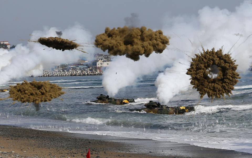 Amphibious assault vehicles of the South Korean Marine Corps throw smoke bombs as they move to land on shore during a U.S.-South Korea joint landing operation drill in Pohang March 31, 2014. The drill is part of the two countries' annual military training called Foal Eagle, which began on February 24 and runs until April 18. North Korea declared a no-sail warning on Monday for areas off its west coast near a disputed border with South Korea and has notified the South that it will conduct firing drills, a South Korean government official said. The warning comes amid heightened tensions surrounding the North after the U.N. Security Council condemned Pyongyang for its mid-range missile launches last week, just as the leaders of South Korea, Japan and the United States met to discuss the North's arms programme. (REUTERS/Kim Hong-Ji)