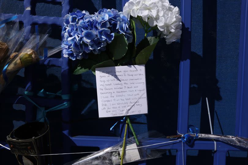 Blue and white bouquets of flowers were left in memory of the former Everton striker