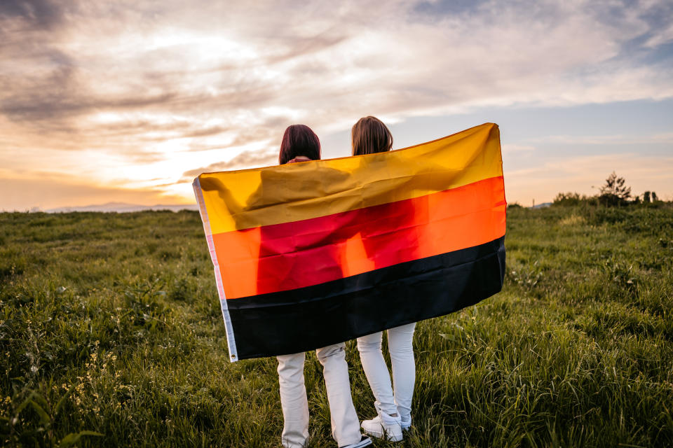 Two women holding a German flag behind their backs