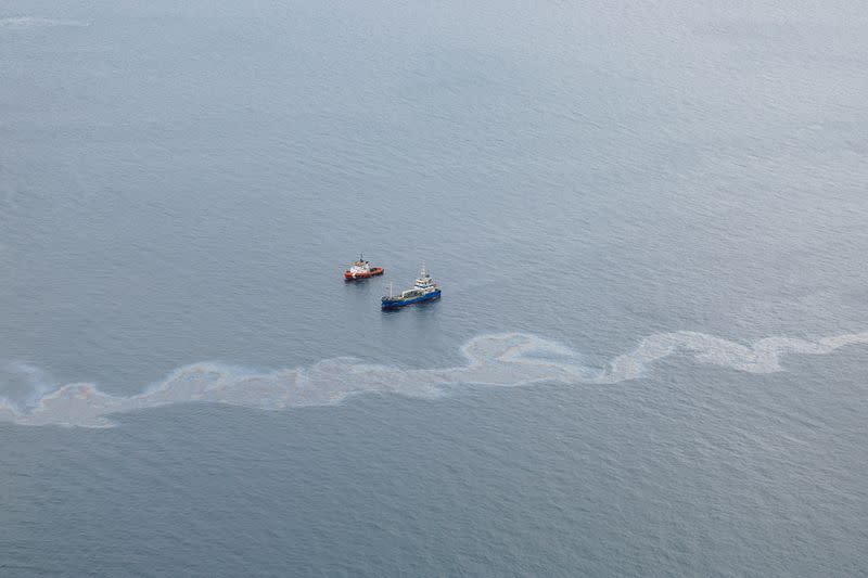 Dos embarcaciones navegan junto al vertido de petróleo del carguero OS 35 que permanece medio hundido tras su colisión con un buque de GNL frente a Gibraltar