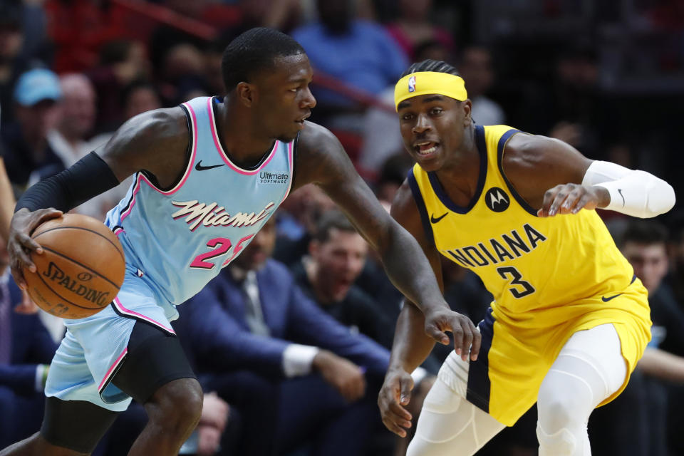 Miami Heat guard Kendrick Nunn (25) drives past Indiana Pacers guard Aaron Holiday (3) during the first half of an NBA basketball game Friday, Dec. 27, 2019, in Miami. (AP Photo/Wilfredo Lee)