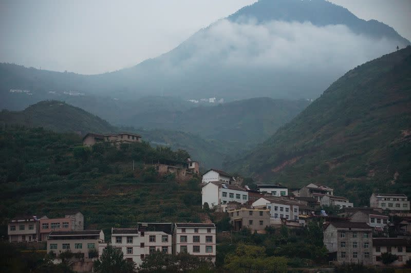 Houses are seen at the foot of a mountain in Sichuan