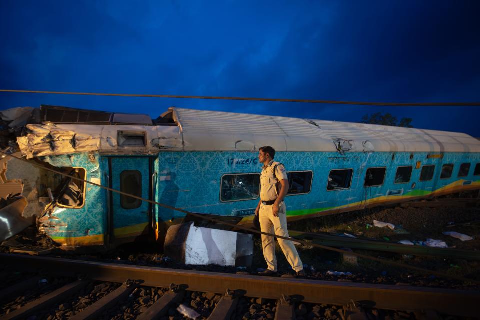 BALASORE, INDIA - JUNE 03: A police man maintains vigil near the wreckage of three trains that crashed on June 03, 2023 in Bahanaga village in Balasore district, India. Local media reports said that the death toll from the deadly crash, about 200km from Odisha's state capital Bhubaneshwar, was approaching 300 as emergency services continued to comb through the wreckage for victims. (Photo by Abhishek Chinnappa/Getty Images) ORG XMIT: 775986380 ORIG FILE ID: 1495653234