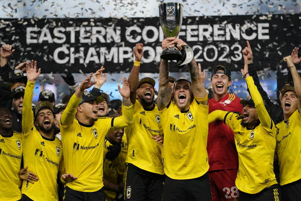 Columbus Crew forward Christian Ramirez (17) holds high the trophy as he celebrates with teammates after the MLS Eastern Conference final soccer match against FC Cincinnati, Saturday, Dec. 2, 2023, in Cincinnati. Columbus won 3-2 in overtime. (AP Photo/Carolyn Kaster)