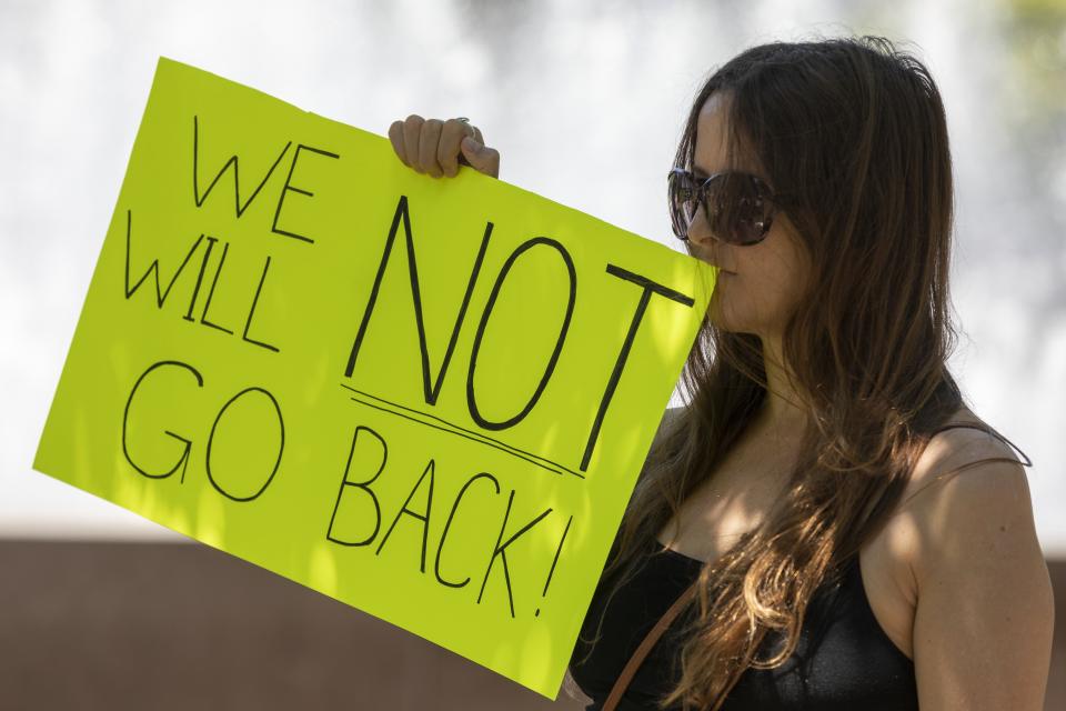 Meg Montgomery holds a sign during an abortion-rights rally, Saturday, June 25, 2022, in Quincy, Mass., a day after the Supreme Court ended constitutional protections for abortion that had been in place nearly 50 years in a decision by its conservative majority to overturn Roe v. Wade. (AP Photo/Michael Dwyer)