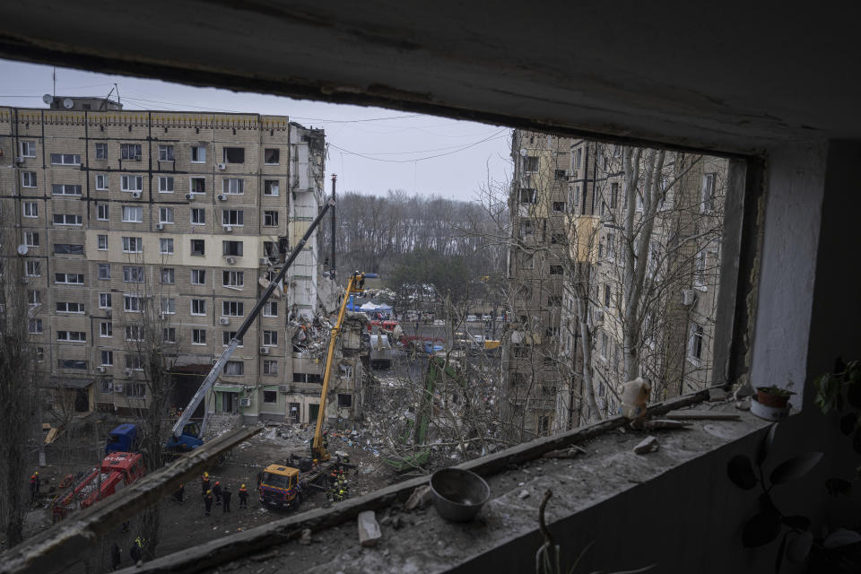 Rescue workers clear the rubble from an apartment building that was destroyed in a Russian rocket attack at a residential neighbourhood in the southeastern city of Dnipro, Ukraine, Monday, Jan. 16, 2023. (AP Photo/Evgeniy Maloletka)