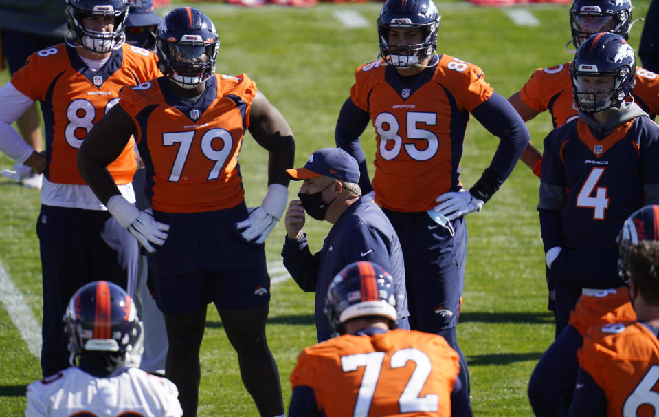 Denver Broncos head coach Viuc Fangio, center, talks with players before they take part in drills during an NFL football practice Wednesday, Oct. 28, 2020, at the team's headquarters in Englewood, Colo. (AP Photo/David Zalubowski)