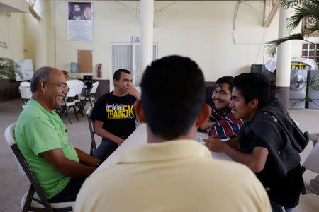 Mexican deportees talk to a volunteer (L) at Our Lady of Guadalupe migrant shelter in Reynosa, Mexico March 14, 2017. Picture taken March 14, 2017. REUTERS/Daniel Becerril