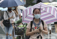 People cross the street in the rain wearing face masks to protect against the spread of the coronavirus in Taipei, Taiwan, Friday, May 29, 2020. (AP Photo/Chiang Ying-ying)