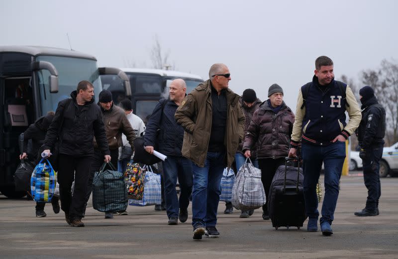 Men get off buses during prisoner of war exchange in Donetsk region