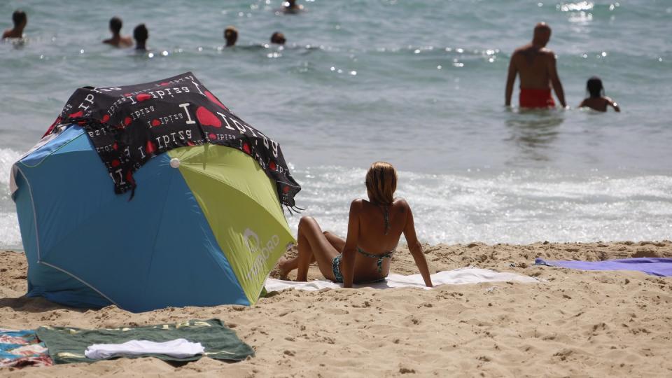 Eine Frau sonnt sich am Strand von Cala Major.