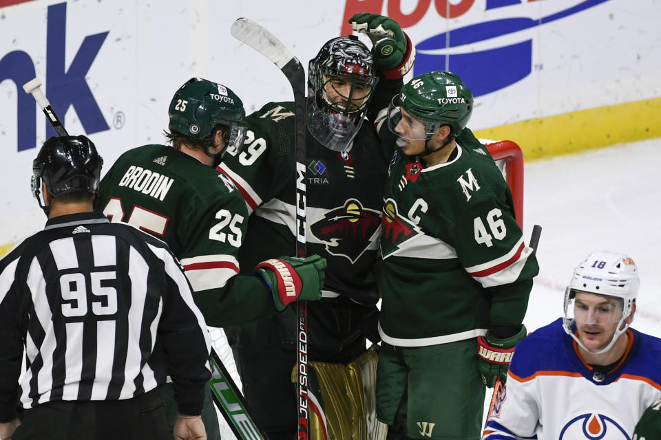 Minnesota Wild defenseman Jared Spurgeon (46) and defenseman Jonas Brodin (25) celebrate with goalie Marc-Andre Fleury after defeating the Edmonton Oilers 2-1 during an NHL hockey game, Monday, Dec. 12, 2022, in St. Paul, Minn. (AP Photo/Craig Lassig)