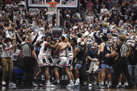 Connecticut players celebrate after regaining possession of the ball in the final second of the team's NCAA college basketball game against Villanova, Tuesday, Feb. 22, 2022, in Hartford, Conn. (AP Photo/Jessica Hill)
