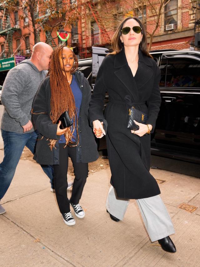 Who made Angelina Jolie's white handbag and black sunglasses