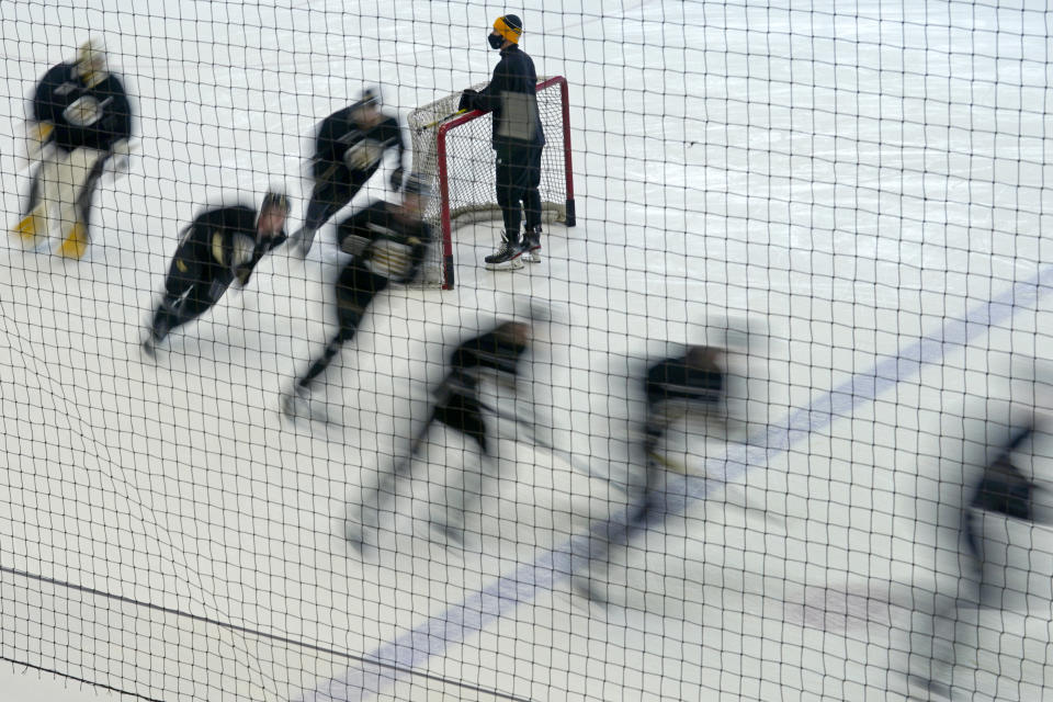 Boston Bruins players skate around a goal during a speed drill at the team's NHL hockey training camp, Monday, Jan. 4, 2021, in Boston. (AP Photo/Elise Amendola)