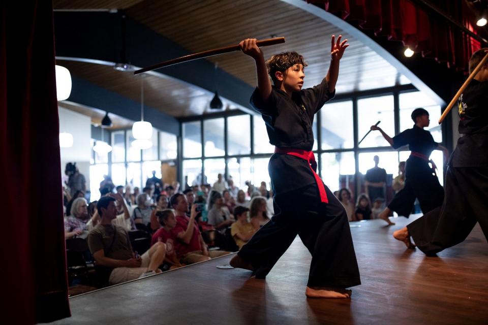 Sam Downey, 13, and others from Lotus Blossom Martial Arts in Murray perform with wooden swords at Natsu Matsuri, a Japanese culture festival at the Japanese Church of Christ in Salt Lake City on Saturday.