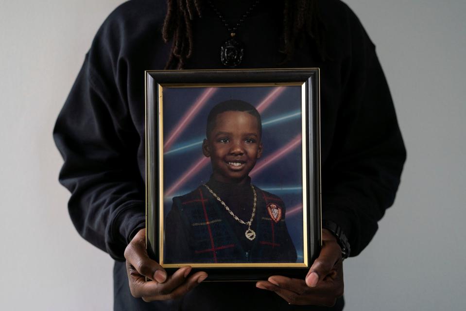 Nathaniel Vickers, 31, of Sterling Heights, holds a photograph of himself in second grade at TES therapy clinic in Troy on Tuesday, April 4, 2023. "Some of the schools I went to were socially and economically disadvantaged, so classes were full and I would just go under the radar because if I had one of my toys or something in my hand to keep me occupied – I'm not causing any problems for anybody, so it's easy to get missed like that," said Vickers, who was diagnosed with autism during graduate school at age 27 following a conversation with a professor. "I like working with kids with autism because I can understand them so well."