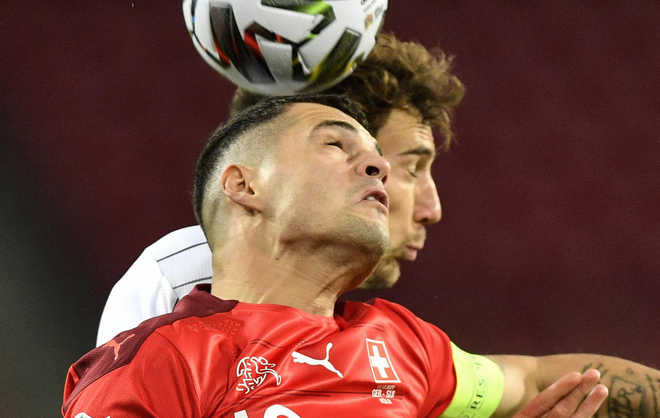 Leon Goretzka (atrás), de Alemania, y Granit Xhaka, de Xuiza, disputan un balón durante un encuentro de la Liga de Naciones, el martes 13 de octubre de 2020 (AP Foto/Martin Meissner)