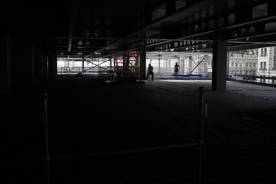 Construction workers putting down the steel flooring over the beams at the 8 Bishopsgate development in London, Thursday, April 1, 2021. When the pandemic struck, about 540,000 workers vanished from London's financial hub almost overnight. Developers of 8 Bishopsgate, are confident that when construction ends late next year, workers and firms will return to fill all 50 floors of the gleaming new office space. (AP Photo/Alastair Grant)