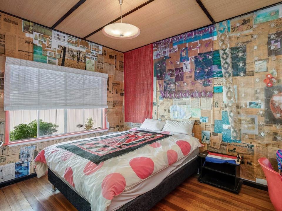 A bedroom with walls covered in newspaper cuttings.