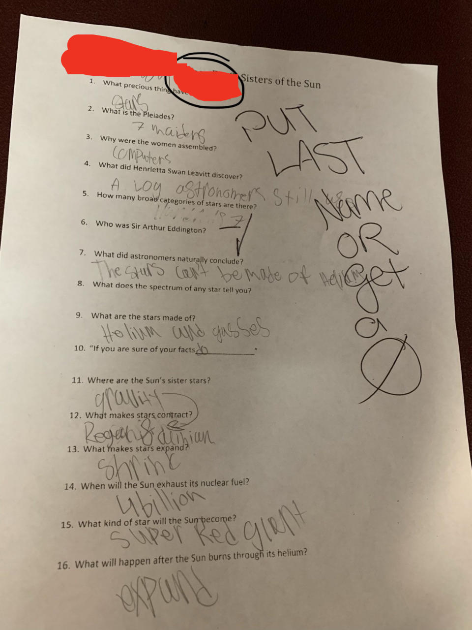 A teacher writing a note on a student's assignment that reads: "Put last name or get a 0"