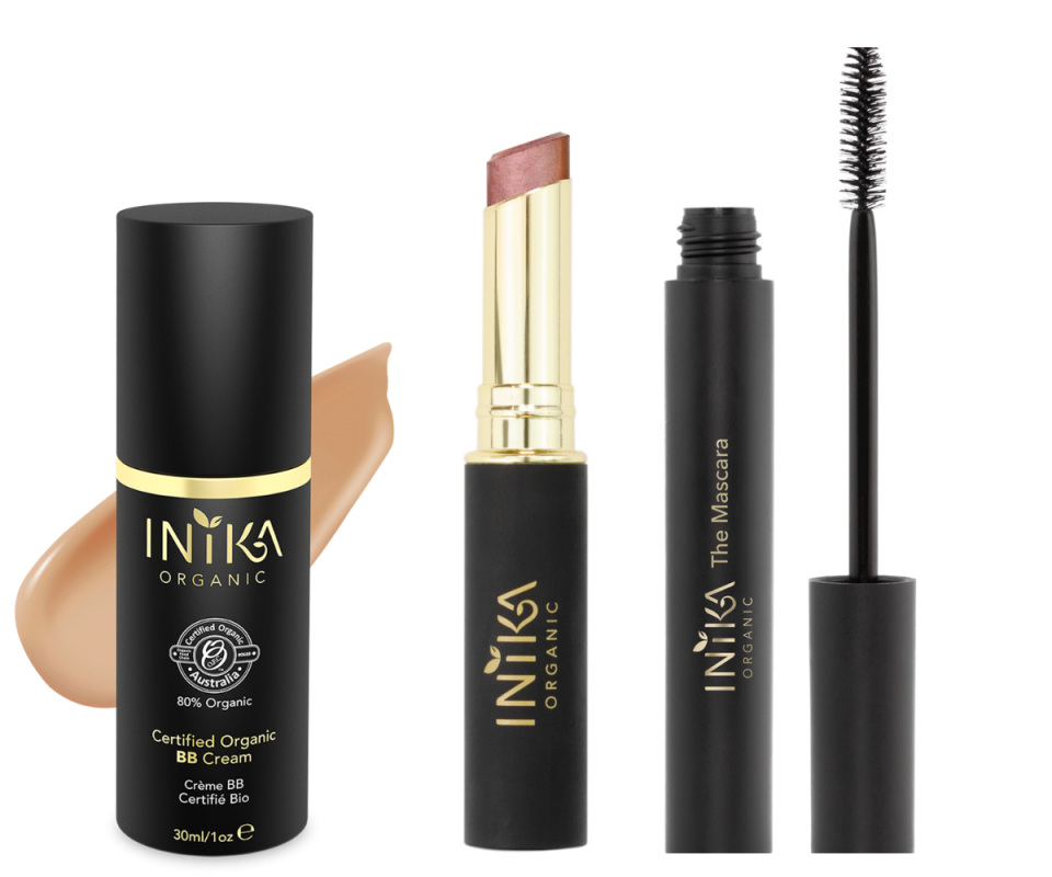 A black BB cream bottle, a pale pink lipstick with the lid off with a gold and black case and a black mascara with the brush sitting next to the pot on a white background.