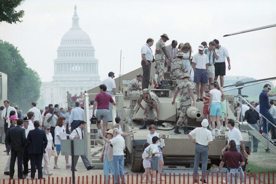 Tourists swarm over an M-1 tank on the Mall near the Capitol on Friday, June 7, 1991 in Washington. The tank and other weapons will be a part of the Desert Shield and Desert Storm Victory Celebration in Washington on Saturday. (AP Photo/Ron Edmonds)
