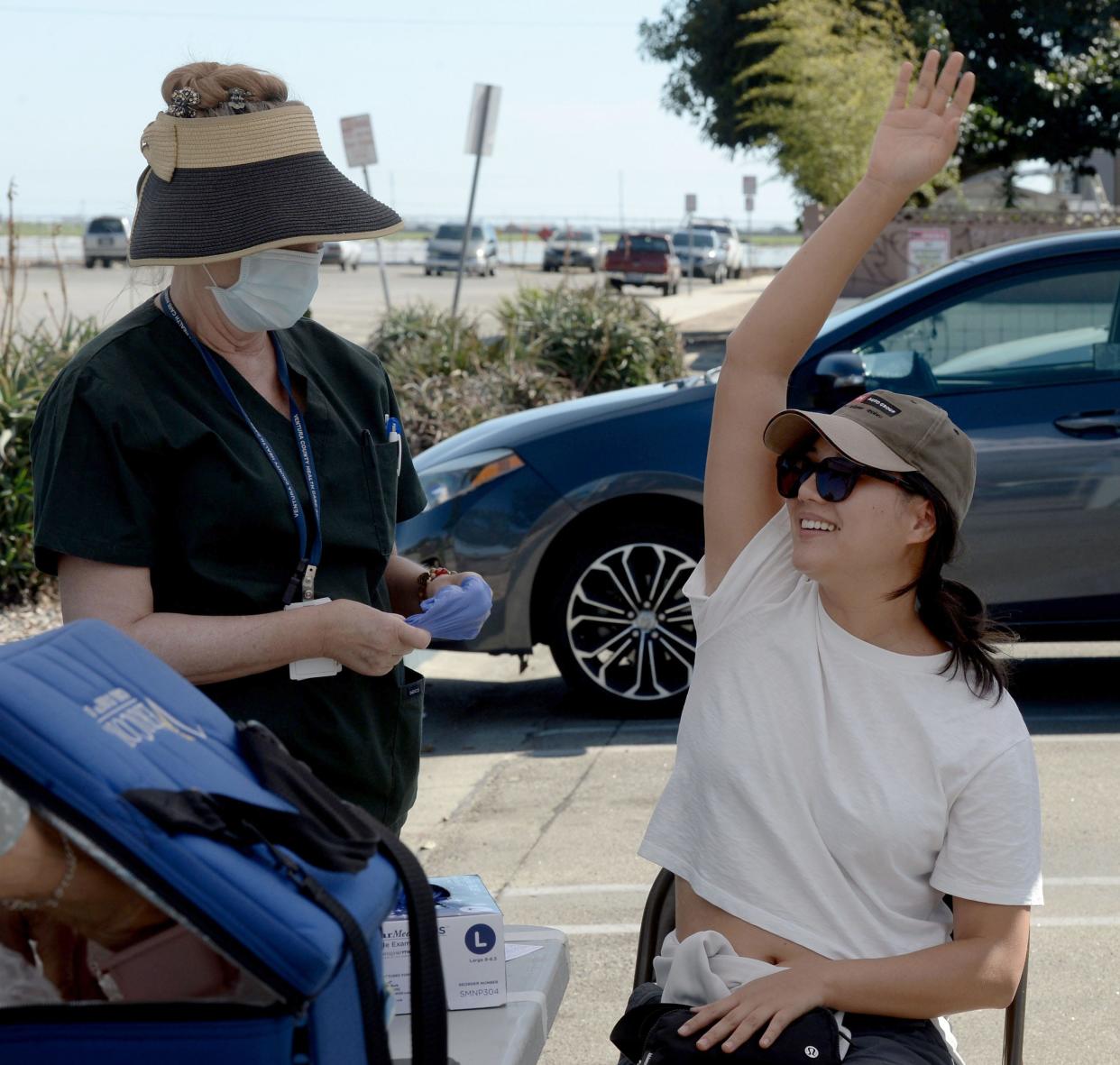 Updated COVID-19 vaccines are expected to be available later this month. In this 2022 picture, nurse Rebecca Rule helps Tessa Chu after she received a booster shot.