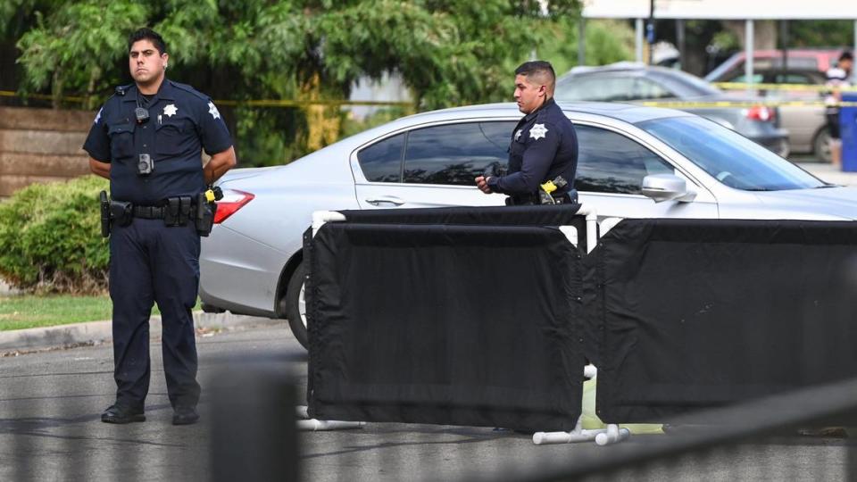 Fresno police officers stand watch at the scene of a homicide that occurred in the roadway on Union Avenue at Cedar near McLane High School on Monday, Sept. 18, 2023.