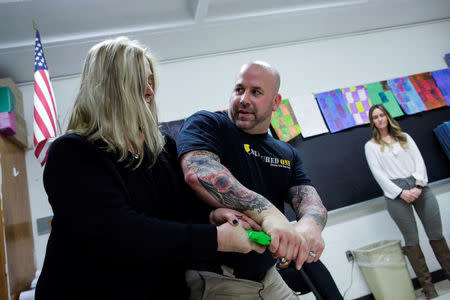 Armoured One CEO Tom Czyz (C) shows school teachers and staff members how to block an attacker during an active shooter training at James I. O'Neill High School in Highland Falls, New York, U.S., December 12, 2017. REUTERS/Eduardo Munoz