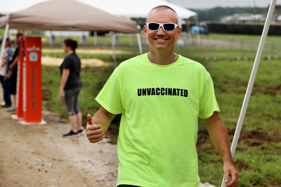 A man wears an 'UNVACCINATED' t-shirt ahead of Donald Trump's 