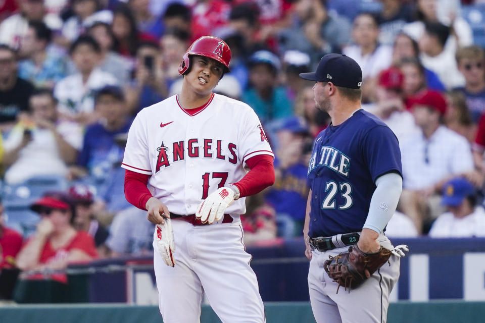 Los Angeles Angels' Shohei Ohtani (17) talks to Seattle Mariners first baseman Ty France (23) after hitting a single during the first inning of a baseball game Thursday, Aug. 3, 2023, in Anaheim, Calif. (AP Photo/Ryan Sun)