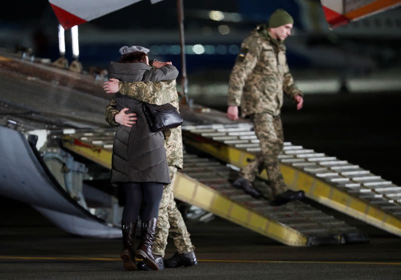 A Ukrainian serviceman exchanged during a prisoners of war swap embraces a relative upon the arrival at an airport outside Kiev