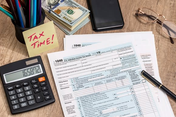 Tax forms and a calculator are laid out.