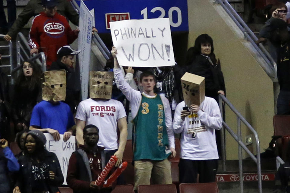 Fans hold signs after the Philadelphia 76ers won an NBA basketball game against the Detroit Pistons, Saturday, March 29, 2014, in Philadelphia. Philadelphia won 123-98, breaking a 26-game losing streak. (AP Photo/Matt Slocum)