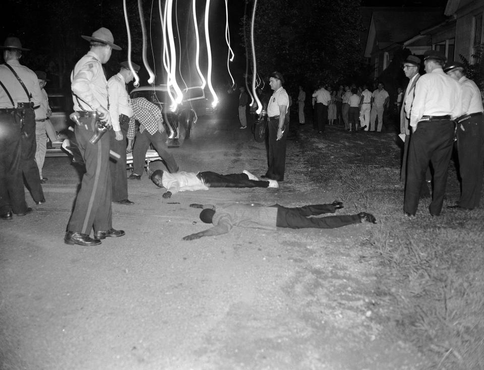 FILE - In this Sept. 24, 1957 file photo, Clarence R. Sanders, an airman at Little Rock Air Force Base, in white jacket, and Ernest Patrick of Little Rock lie on the ground after a chase by police in downtown Little Rock, Ark. The men and their three female companions fled from police after a fight with some white youths. They were captured after their car went out of control in East Little Rock. Neither man was seriously hurt were taken police custody. Five decades and $1 billion after an infamous racial episode made Little Rock a symbol of school segregation, the legal fight to ensure all of its children receive equal access to education has ended. (AP Photo/Ferd Kaufman, File)