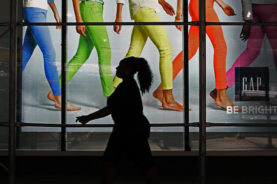 A woman walking pass the display window of a Gap Store in Time Square, New York City. (photo: Siemond Chan)