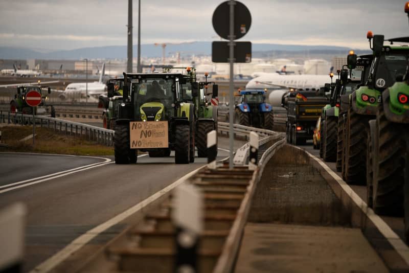 Tractors drive past on a road at Frankfurt Airport. Hundreds of farmers demonstrate against the expiry of tax refunds for agricultural diesel with a protest drive around Germany's busiest airport in Frankfurt. Ardavan Safari/dpa