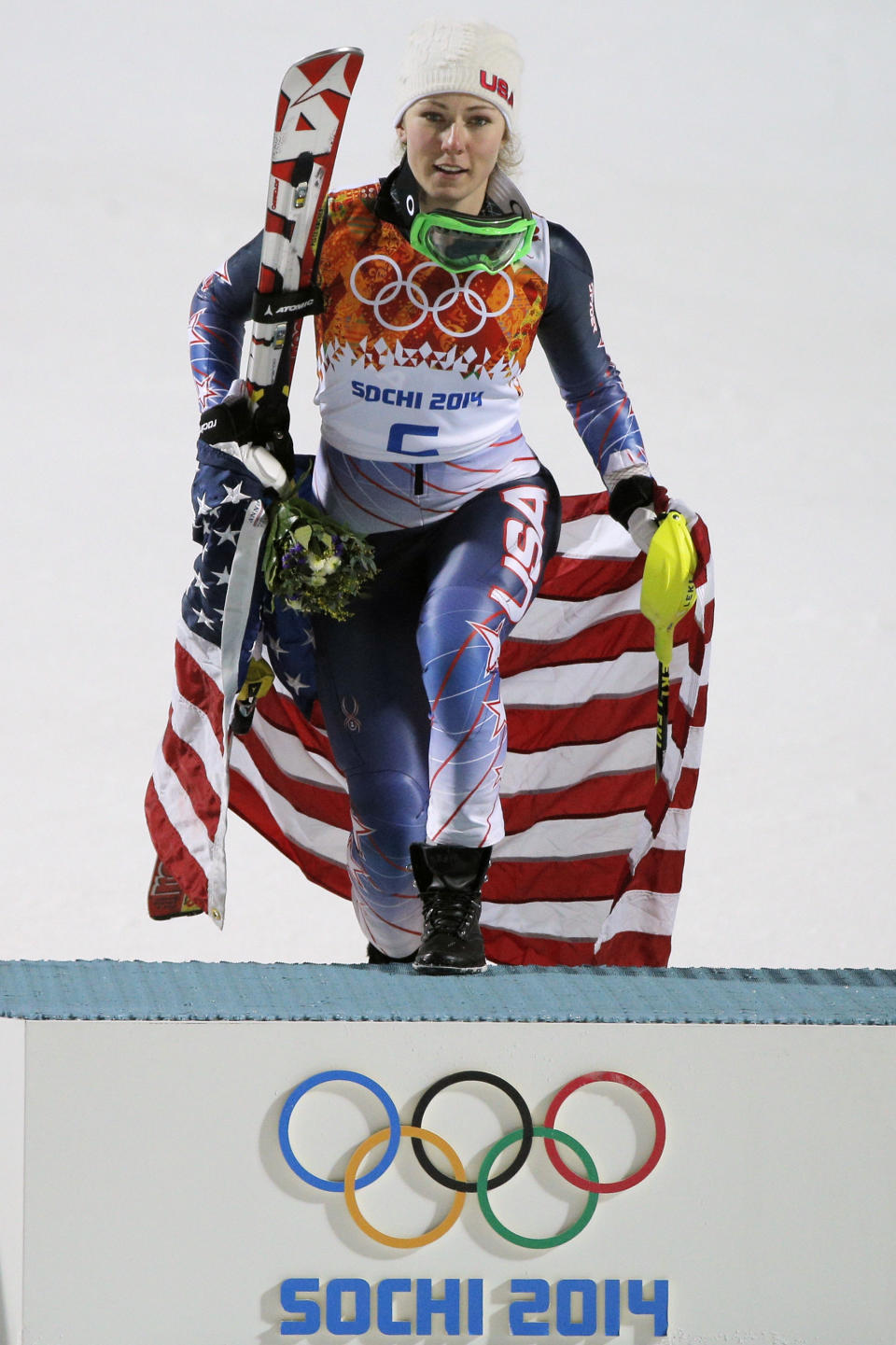 Women's slalom gold medal winner Mikaela Shiffrin steps onto the podium at the Sochi 2014 Winter Olympics, Friday, Feb. 21, 2014, in Krasnaya Polyana, Russia. (AP Photo/Christophe Ena)