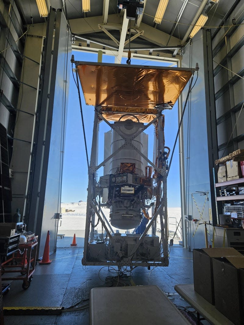 The GUSTO telescope hangs from the hangar crane during telescope pointing tests.