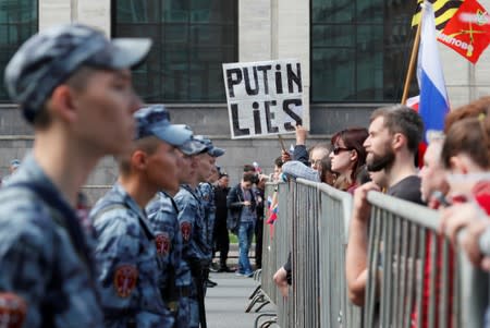 Members of Russia's National Guard watch protesters during a rally in Moscow