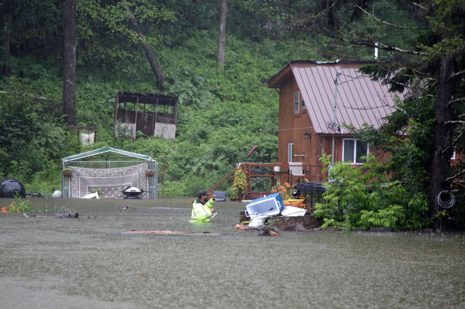 Kaleb McIntire, 33, wades into floodwaters surrounding his aunt’s home near the Ottauquechee River in Bridgewater, Vt., on Monday (AP)