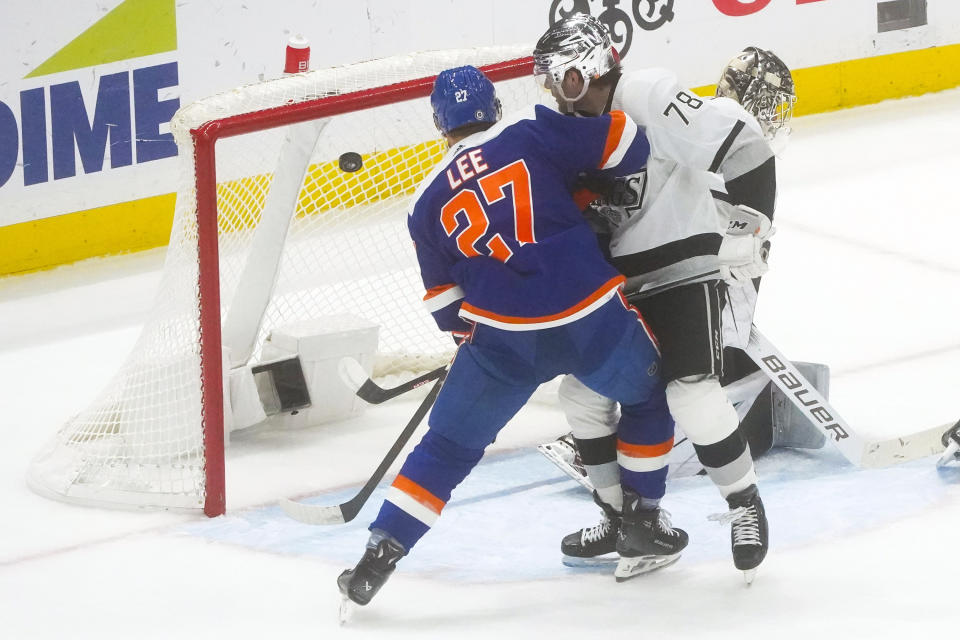 New York Islanders' Anders Lee, left, and Los Angeles Kings' Alex Laferriere, right, watch as a shot bounces off the Kings' goal during the second period of an NHL hockey game Saturday, Dec. 9, 2023, in Elmont, N.Y. (AP Photo/Bebeto Matthews)