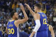 March 31, 2019; Oakland, CA, USA; Golden State Warriors guard Stephen Curry (30) celebrates with center Andrew Bogut (12) against the Charlotte Hornets during the second quarter at Oracle Arena. Mandatory Credit: Kyle Terada-USA TODAY Sports