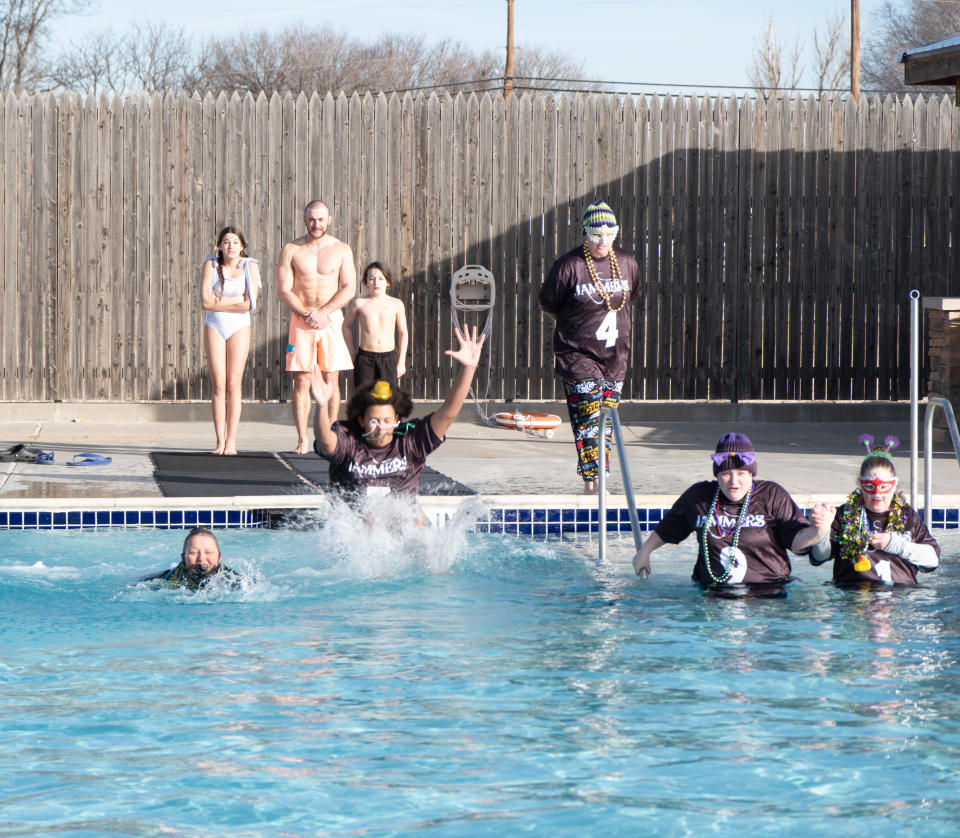 A group works their way across the cold water at the Polar Plunge Saturday morning at the Amarillo Town Club.