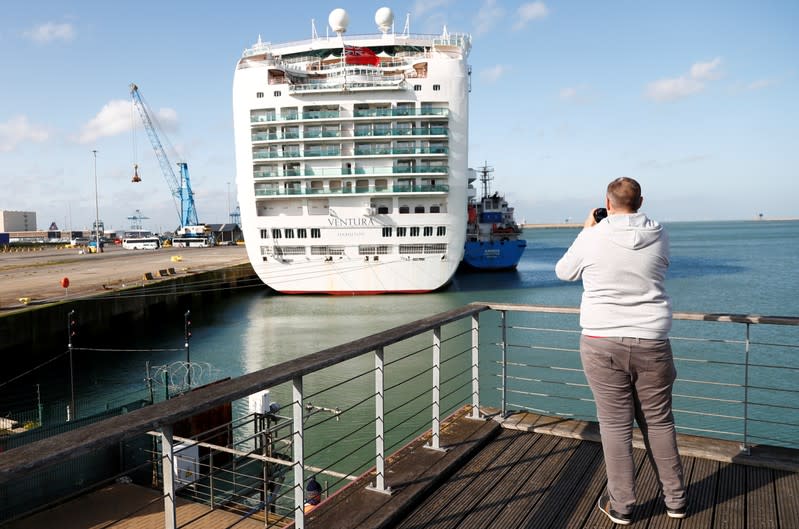 A man takes a picture of Ventura cruise ship in the port of Zeebrugge
