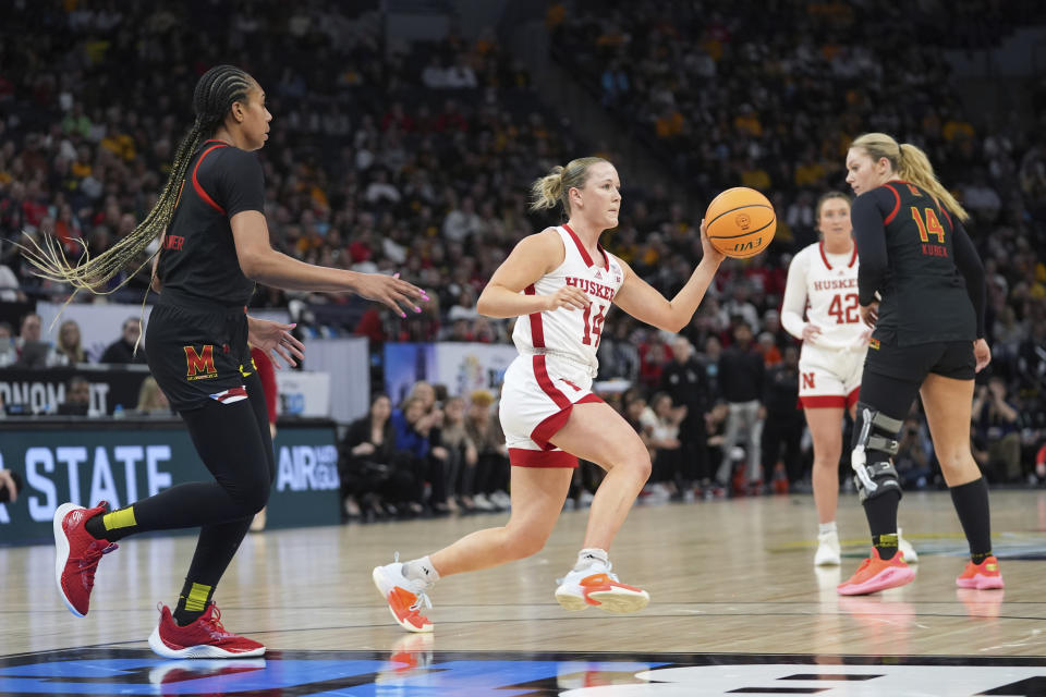 Nebraska guard Callin Hake, center, dribbles across the court as Maryland guard Jakia Brown-Turner, left, defends during the second half of an NCAA college basketball game in the semifinals of the Big Ten women's tournament Saturday, March 9, 2024, in Minneapolis. (AP Photo/Abbie Parr)